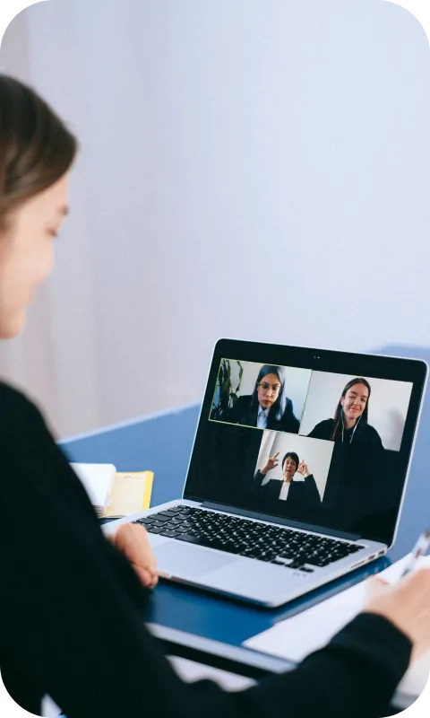 A student at a laptop with three participants of an online lesson on the screen