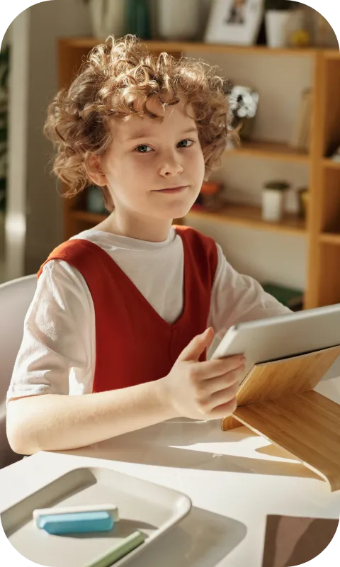 A child with a tablet at a desk